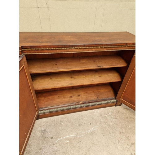 1030 - A George IV rosewood and gilt brass side cabinet, with fabric panel doors, 132.5cm wide.... 