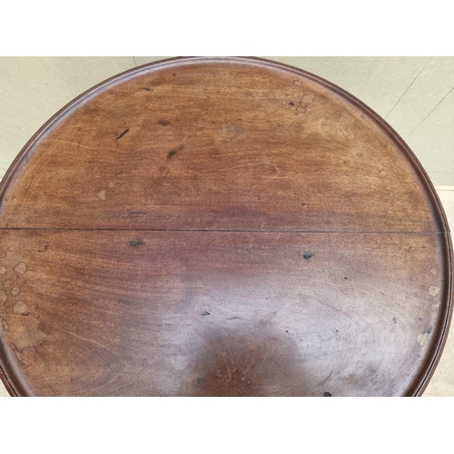 1034 - Two mahogany tilt-top tripod tables, comprising: a George III circular example, 60cm diameter; and a... 