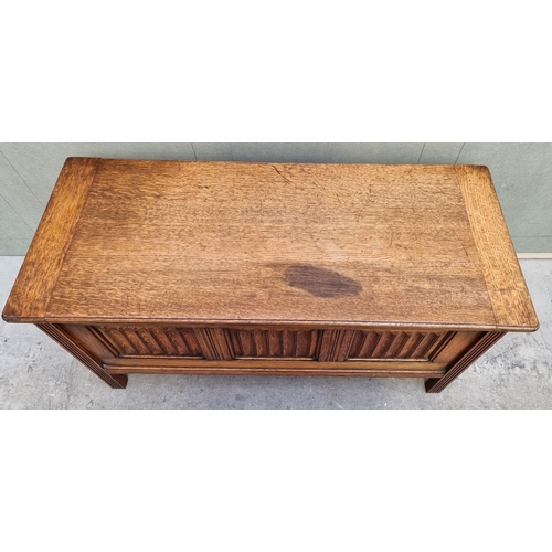 1072 - A reproduction oak linenfold coffer, 106.5cm wide. 