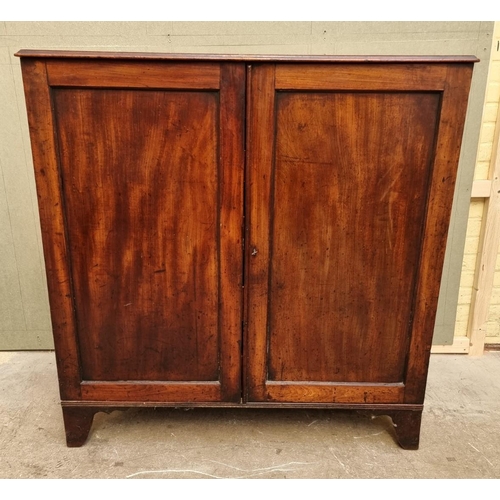 1083 - An unusual George III mahogany press cupboard, the pair of panel doors enclosing a frieze drawer and... 