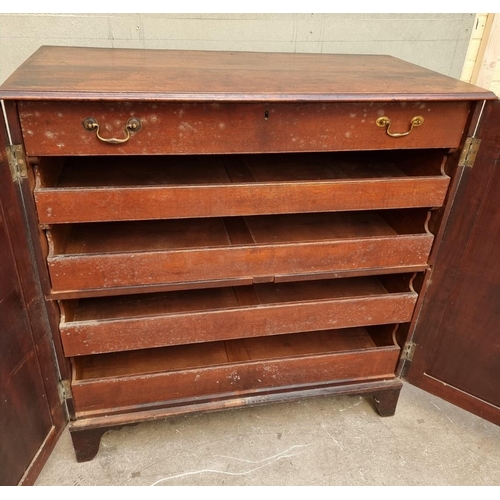 1083 - An unusual George III mahogany press cupboard, the pair of panel doors enclosing a frieze drawer and... 