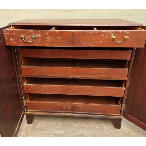 1083 - An unusual George III mahogany press cupboard, the pair of panel doors enclosing a frieze drawer and... 