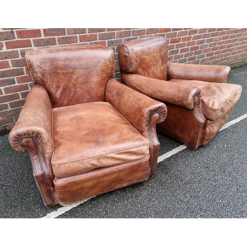 1089 - A pair of brown leather club chairs. 