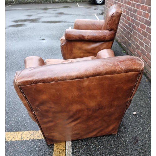 1089 - A pair of brown leather club chairs. 