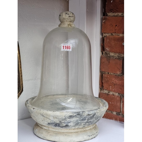 1165 - A glass bell cloche and pottery stand, 41cm high.