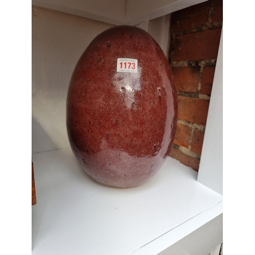 1173 - A sang de boeuf glazed terracotta egg, 31cm high. 