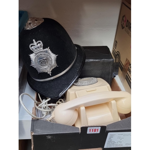 1181 - A mixed lot, comprising: a police helmet; a vintage telephone; a boxed gas mask; two military caps; ... 