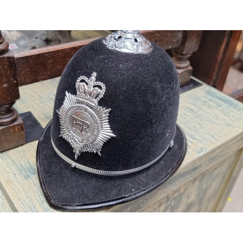 1181 - A mixed lot, comprising: a police helmet; a vintage telephone; a boxed gas mask; two military caps; ... 