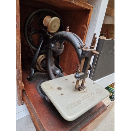 1185 - An early 20th century Willcox & Gibbs sewing machine, in pine box.