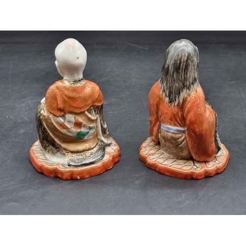 1361 - A pair of Japanese Kutani porcelain seated figures, each inscribed to base, 11cm high; together with... 