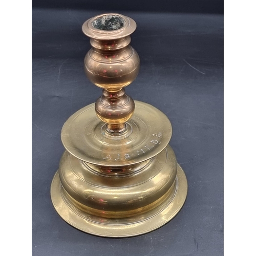 1363 - An antique Continental brass candlestick, inscribed 'AIS MKD', 20cm high.  ... 