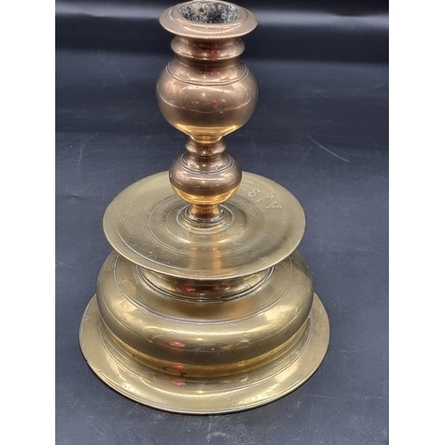 1363 - An antique Continental brass candlestick, inscribed 'AIS MKD', 20cm high.  ... 