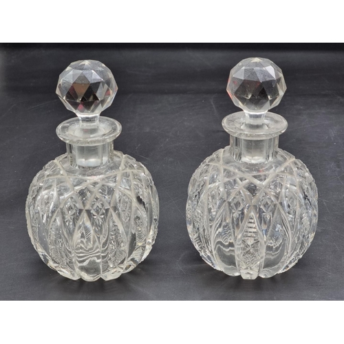 1368 - A pair of cut glass inkwells and stoppers, 14cm high; together with a green glass dump paperweight, ... 