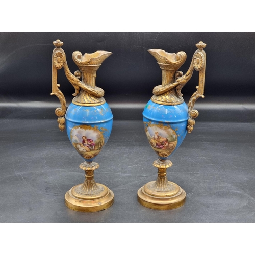 1400 - A pair of Sevres style gilt brass mounted ewers, 31cm high.