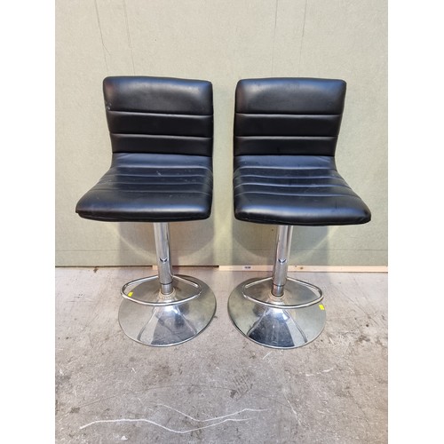 1632 - A pair of black vinyl and chrome bar stools.