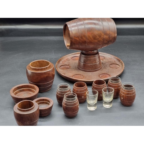 1467 - A treen spirit barrel, on integral tray base, with six tot glasses; together with a matching graduat... 