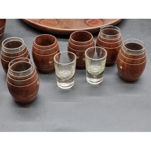 1467 - A treen spirit barrel, on integral tray base, with six tot glasses; together with a matching graduat... 