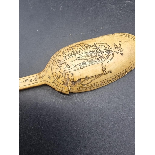 1534 - A rare 18th century Scrimshaw carved horn spoon, finely engraved with a Bavarian figure holding a ri... 