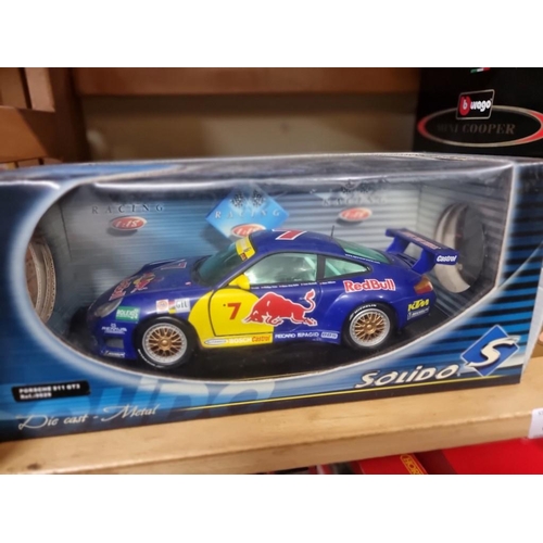 37 - A Solido Porsche 911 GT3 Red Bull Racing; together with two Burago cars, all boxed. (3)... 