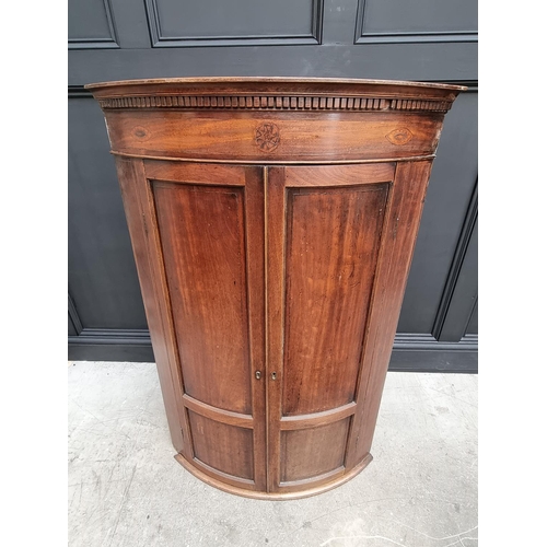 1036 - A George III mahogany and inlaid bowfront hanging corner cupboard, 119 x 78cm.