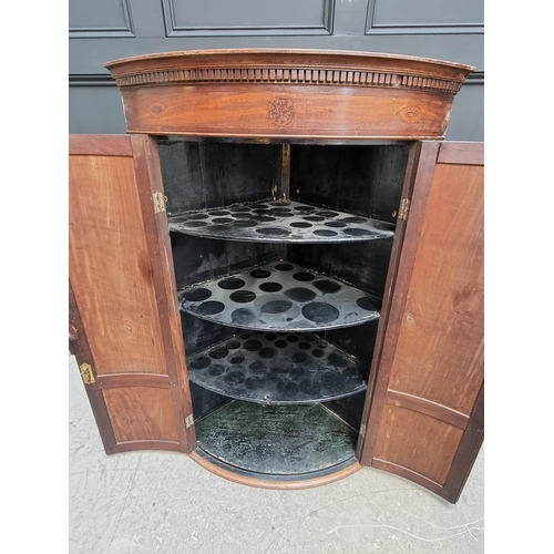 1036 - A George III mahogany and inlaid bowfront hanging corner cupboard, 119 x 78cm.