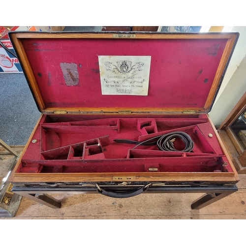 1099 - An antique leather and brass bound shotgun case, 85cm wide, on later stand.