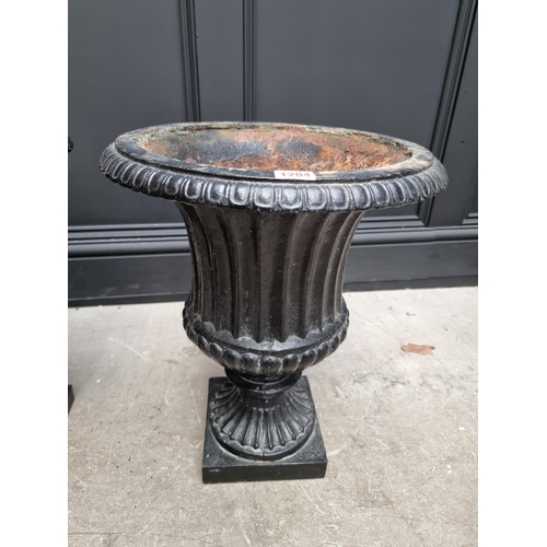 1204 - A pair of black painted cast iron Campana urns and stands, 69cm high.