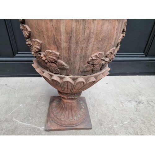 1207 - A large red composition stone twin handled urn, 84cm high, on associated pedestal, total height 132c... 