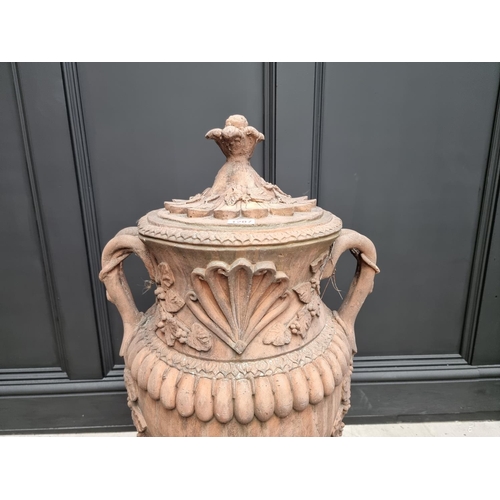 1207 - A large red composition stone twin handled urn, 84cm high, on associated pedestal, total height 132c... 