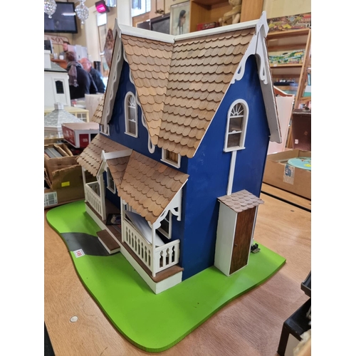 149 - Doll's House: a two storey blue painted wooden doll house with tiled roof, 55cm high x 50cm wide on ... 