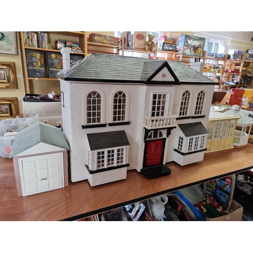 150 - Dolls House: a large two storey wooden doll house, 89cm wide x 62cm high; together with garage and c... 