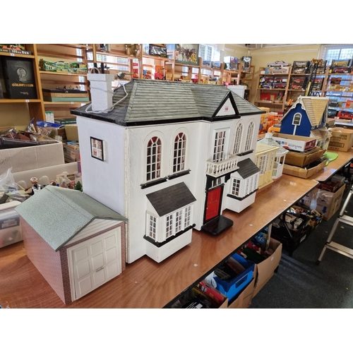 150 - Dolls House: a large two storey wooden doll house, 89cm wide x 62cm high; together with garage and c... 