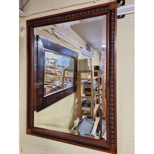 1112 - An Edwardian carved walnut framed rectangular wall mirror, with bevelled plate, 82.5 x 61.5cm.... 