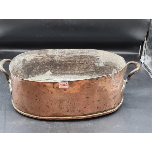 1340 - A large Victorian copper twin handled pan or kettle, inscribed 'Keswick Hotel Co', 57cm wide.... 