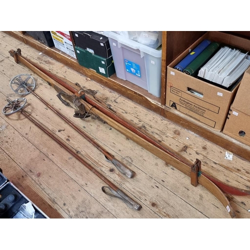 1357 - A pair of vintage wooden skis and poles, the skis 202cm long.