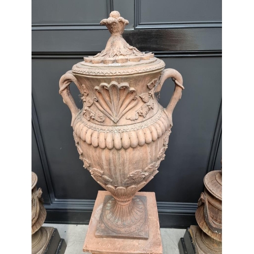 1207 - A large red composition stone twin handled urn, 84cm high, on associated pedestal, total height 132c... 