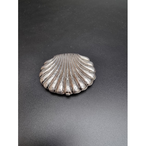 419 - A vintage white metal clamshell coin purse, having chased decoration, 5.9cm wide.