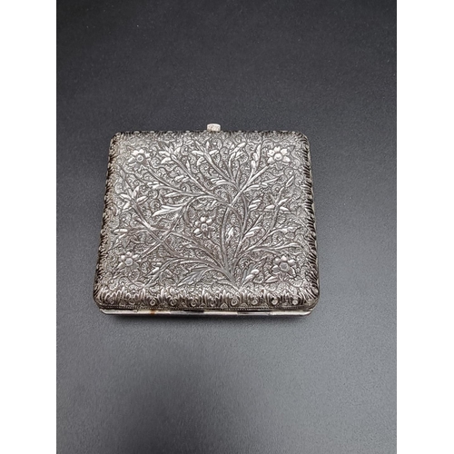 423 - An Anglo Indian white metal cigarette case, having chased floral decoration, 87mm.