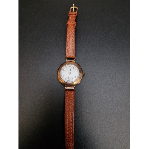 519 - A 9ct gold manual wind ladies wristwatch, on brown leather strap.