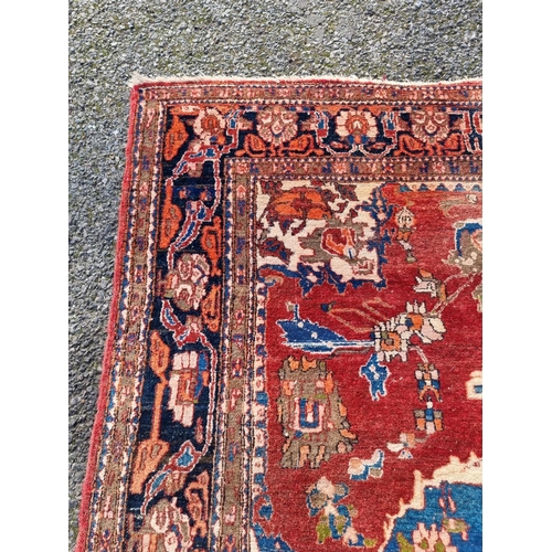 1012 - A Persian carpet, having central floral medallion, with floral cartouches to each corner, with ... 
