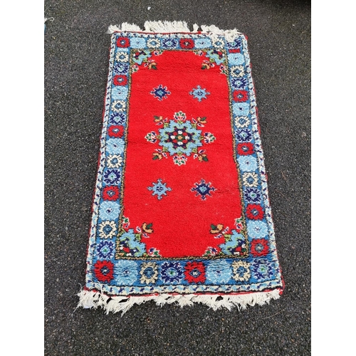 1019 - A floral design rug, on red ground, 143 x 84cm. 