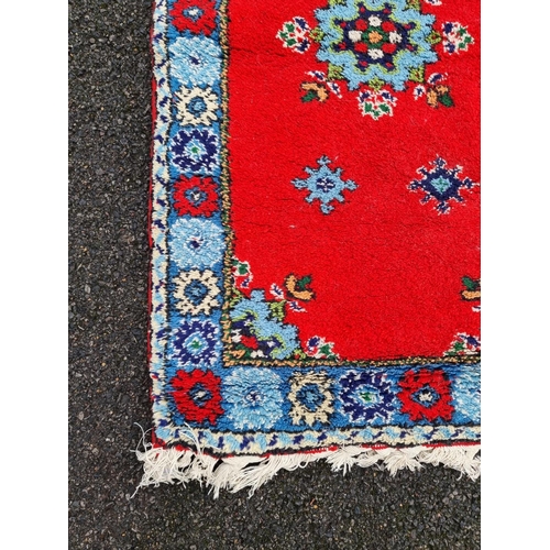 1019 - A floral design rug, on red ground, 143 x 84cm. 