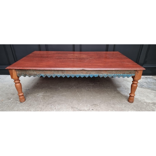 1034 - A large Eastern stained wood rectangular low occasional table, with blue painted and carved frieze, ... 