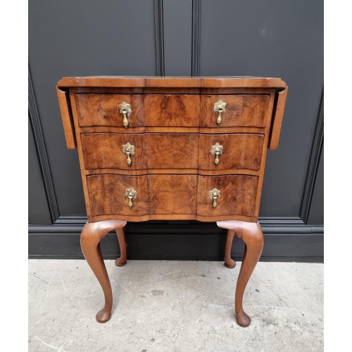 1038 - A 1930s figured walnut and crossbanded three drawer side table, with drop leaves and serpentine fron... 