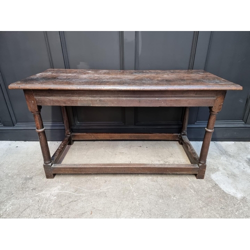 1063 - A late 17th century oak rectangular table, with carved frieze to one long side and peripheral stretc... 