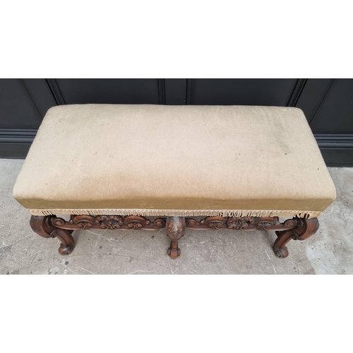 1067 - A William and Mary style carved walnut and upholstered long stool, 104cm wide.