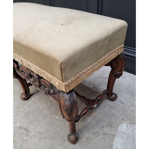 1067 - A William and Mary style carved walnut and upholstered long stool, 104cm wide.