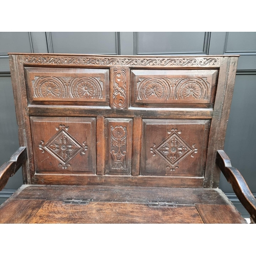 1086 - An antique carved oak box seat settle, 136cm wide.