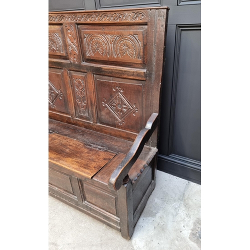 1086 - An antique carved oak box seat settle, 136cm wide.