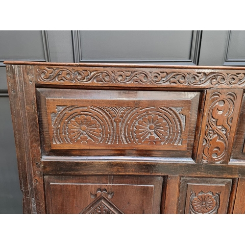 1086 - An antique carved oak box seat settle, 136cm wide.